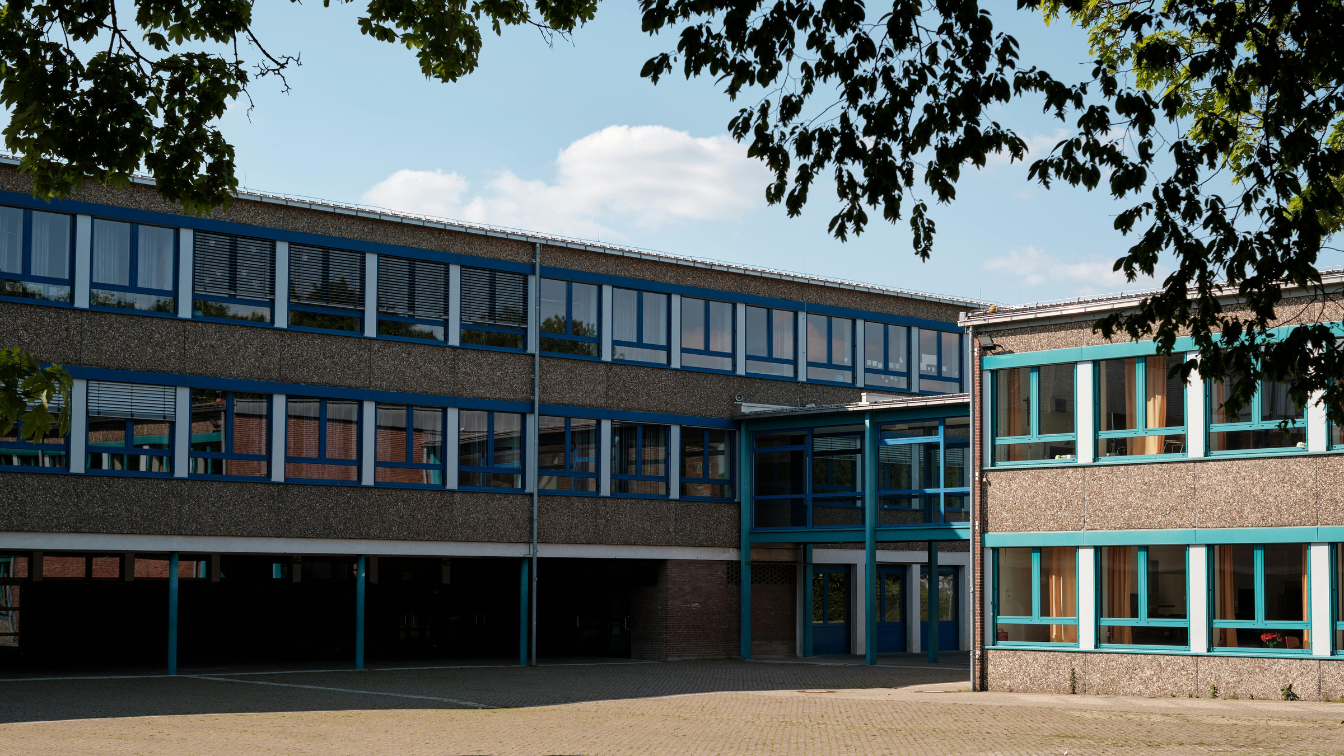 A school shaded by trees on a hot day.